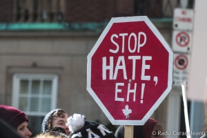 A stop sign reading "stop hate, eh"
